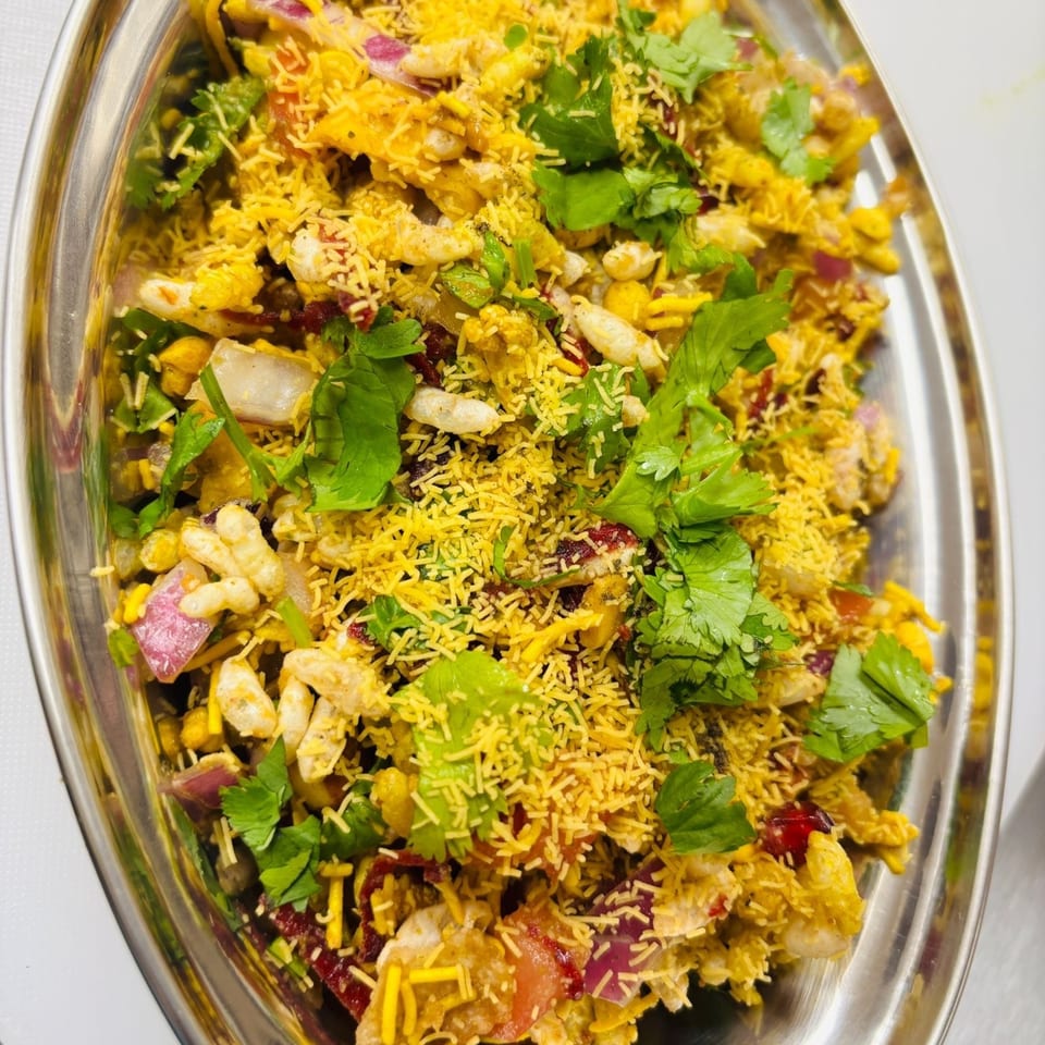 Close-up of Indian Bhel Puri, a street food snack with puffed rice, vegetables, and savory toppings.