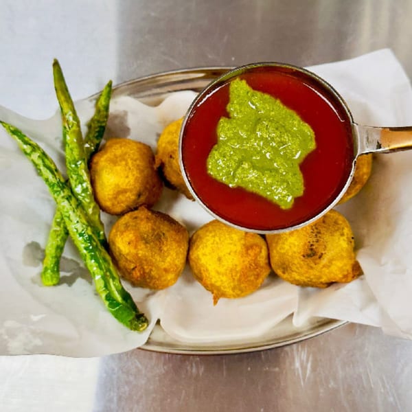 Golden-fried Indian street food fritters with green chilies, served with red and green chutneys.
