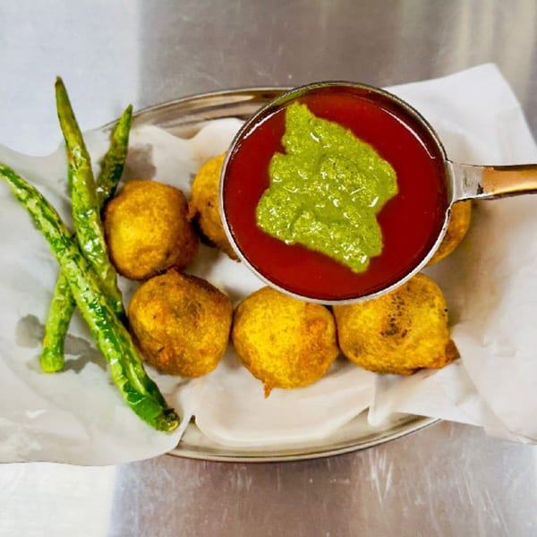 Golden-fried Indian street food fritters with green chilies, served with red and green chutneys.